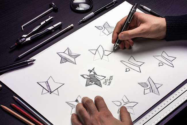 une planche à dessin sur laquelle on aperçoit des esquisses de logos
