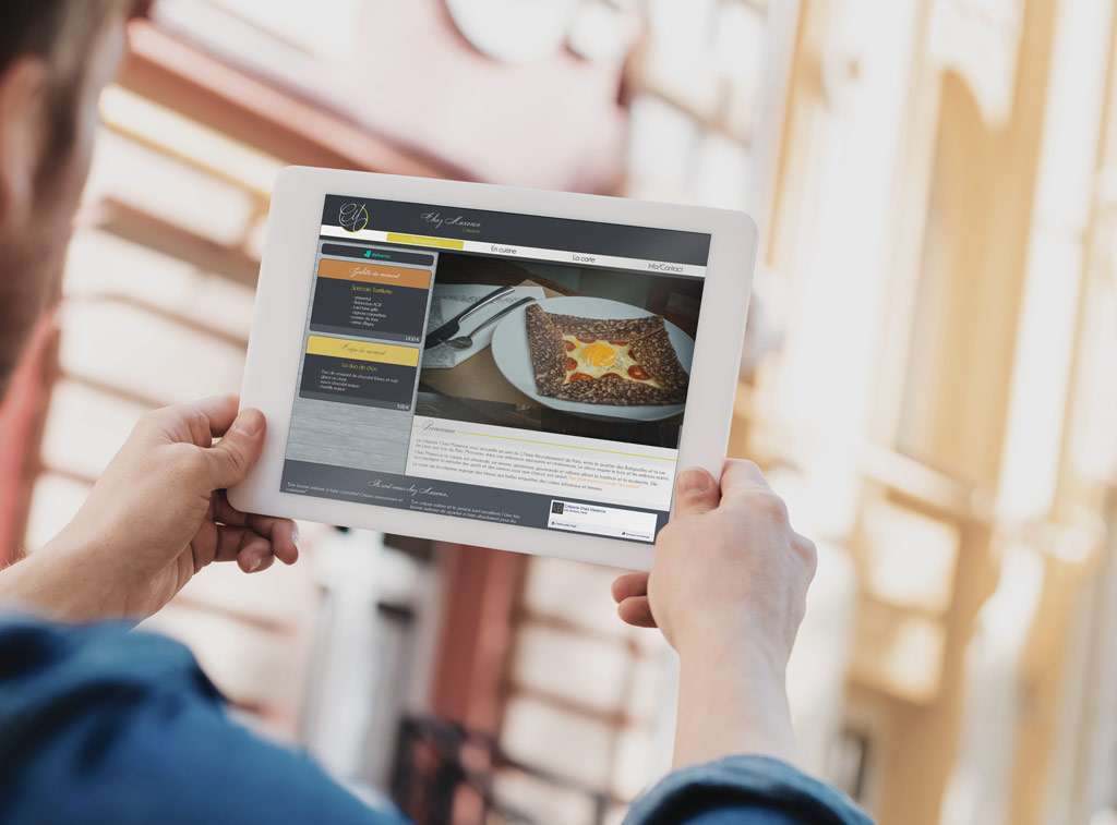 Un passant qui consulte le site internet du restaurant sur sa tablette