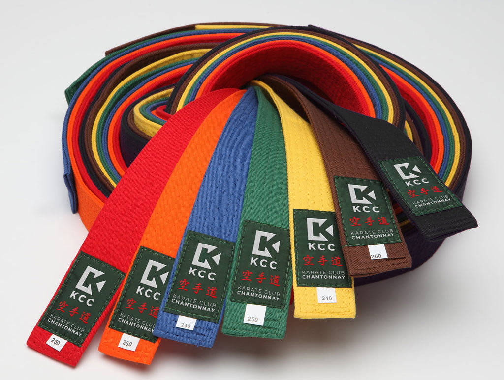 des ceintures de karaté de toutes les couleurs dont l'étiquette est brodée avec le logo du club