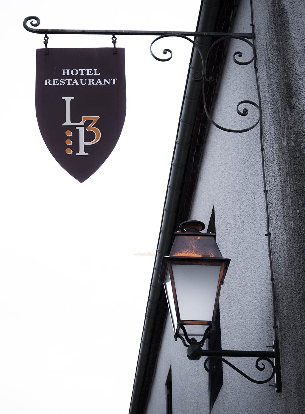 l'ancienne enseigne "bouclier" en métal du restaurant a été restaurée pour pouvoir y apposer le nouveau logo.